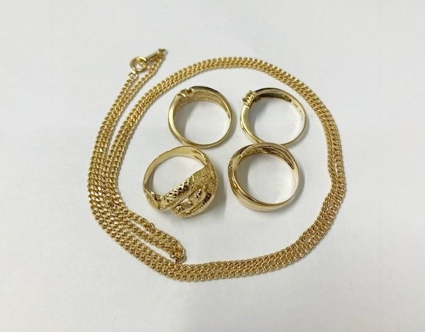 金色の指輪4点とチェーンネックレスを並べた貴金属